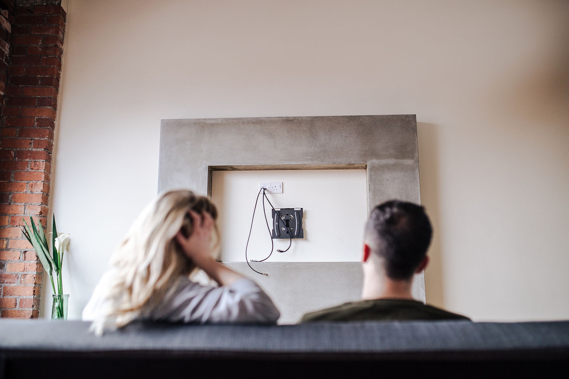 Couple looking at wall with missing TV